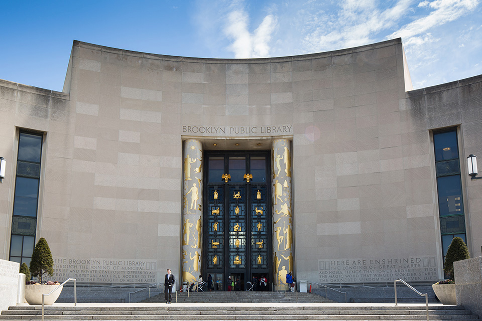 The facade of the Brooklyn Public Library on a sunny day with blue skies.; Watch or Read on CBS