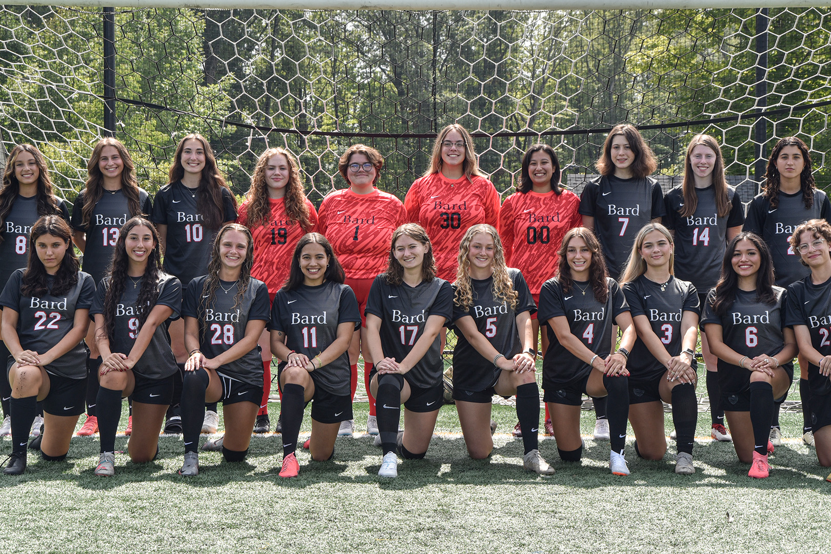 A team of women soccer players smiles for the camera.