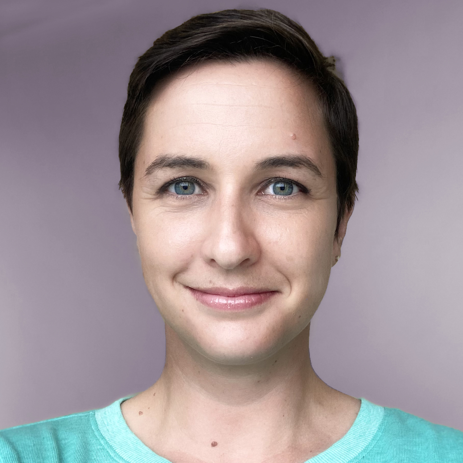 A woman with short hair looks at the camera with a slight smile.