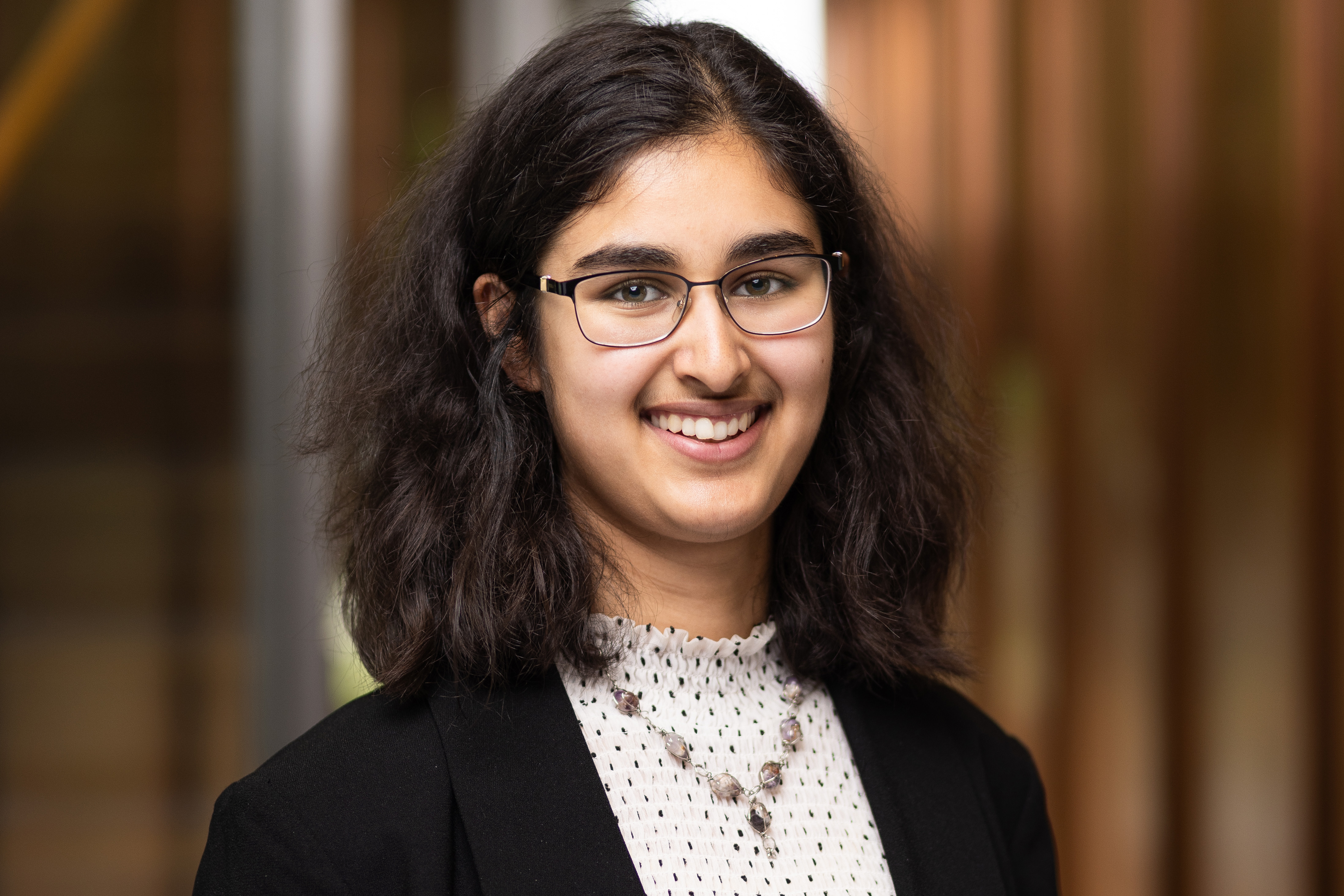 Manar Hashmi smiling in a professional photo.