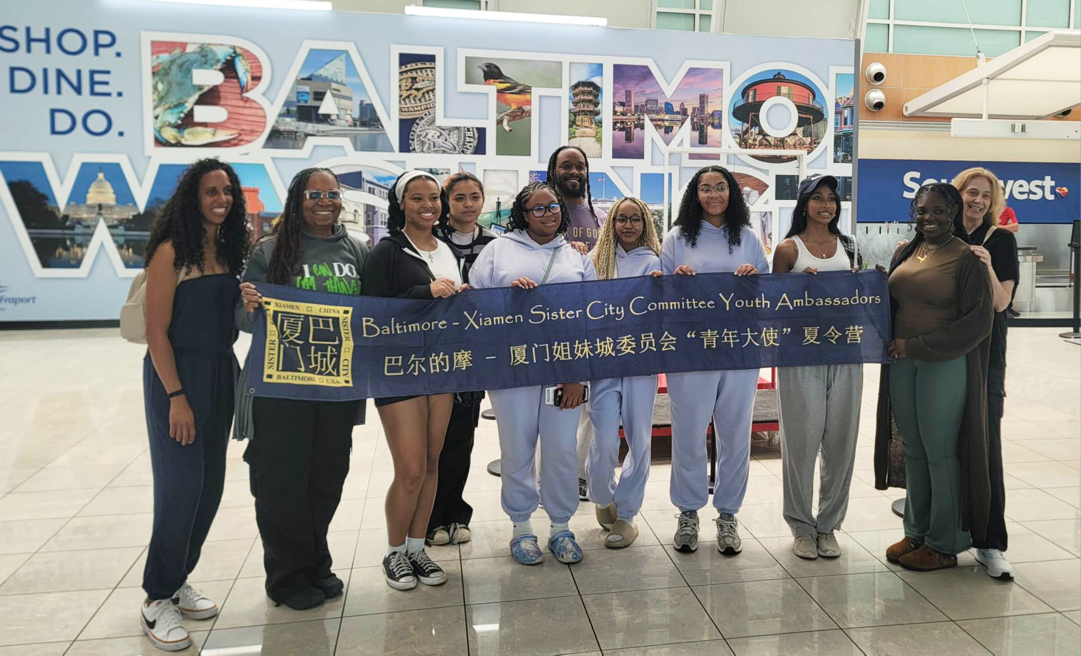 A group of student ambassadors hold up a banner.