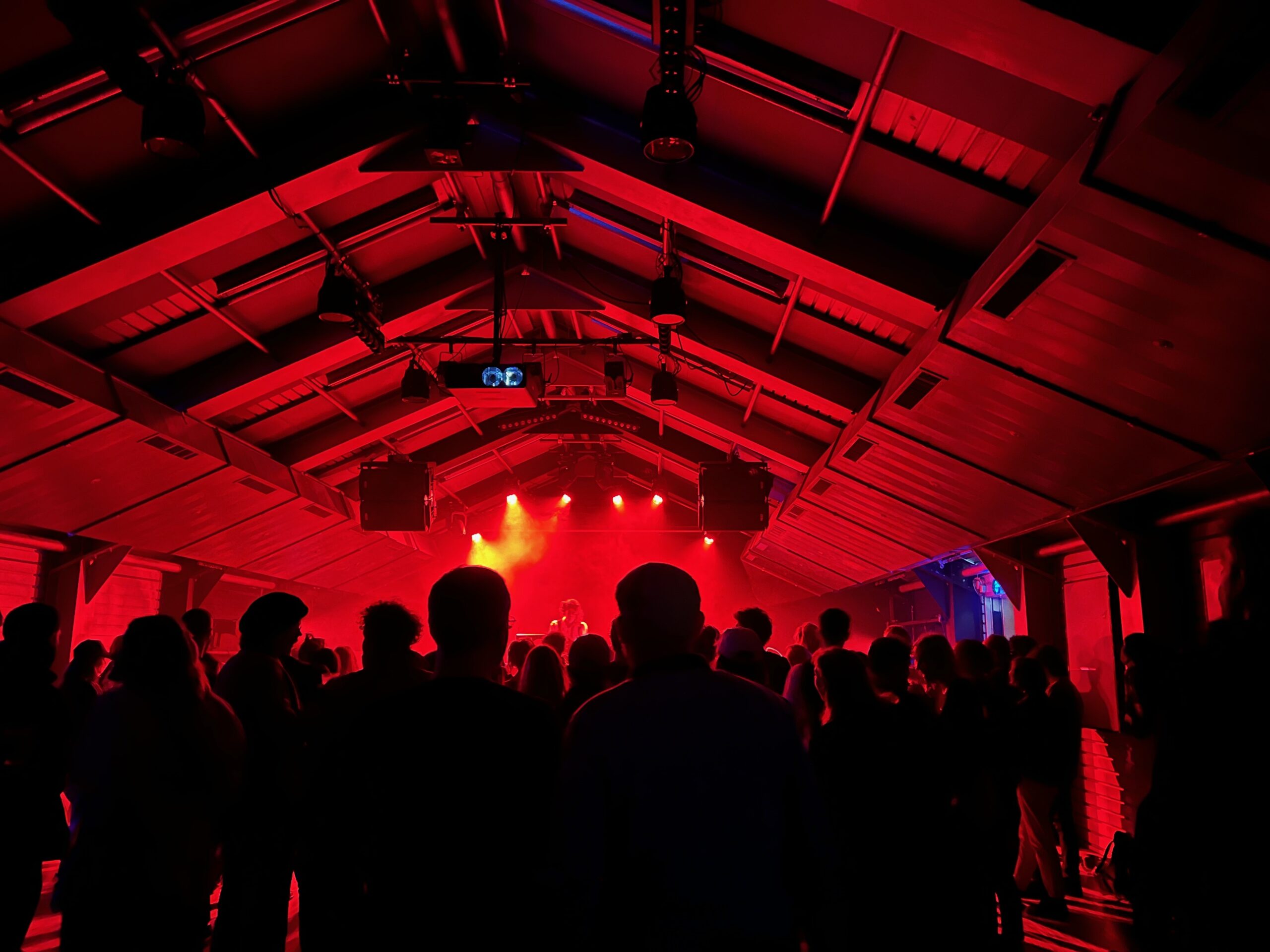 A stage and an audience silhouetted by red light.