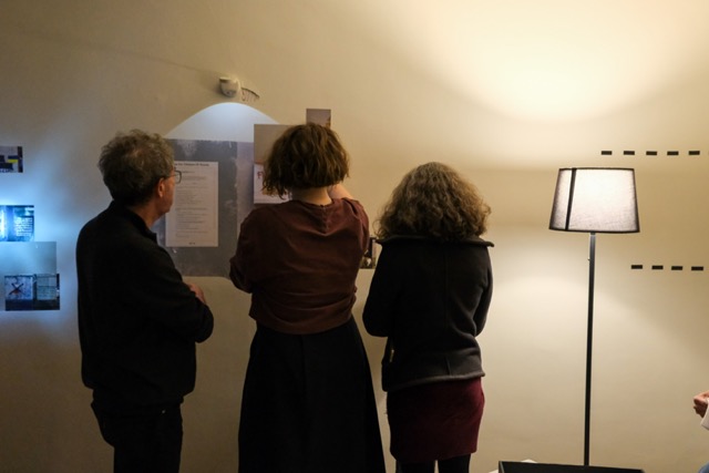 three people study text on a wall