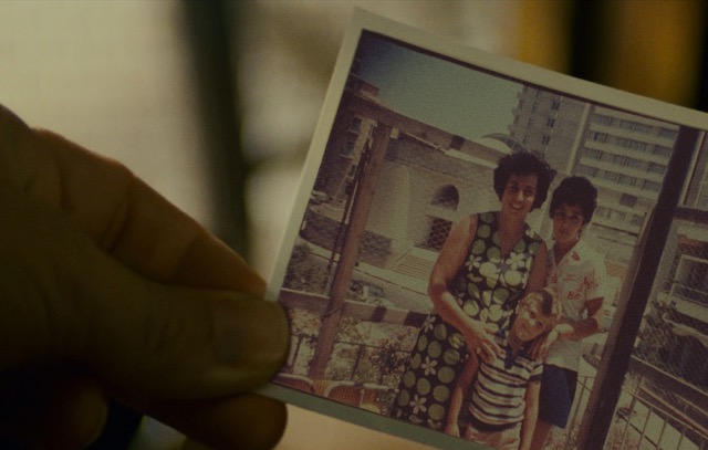 A family photo held in the artist's hand.