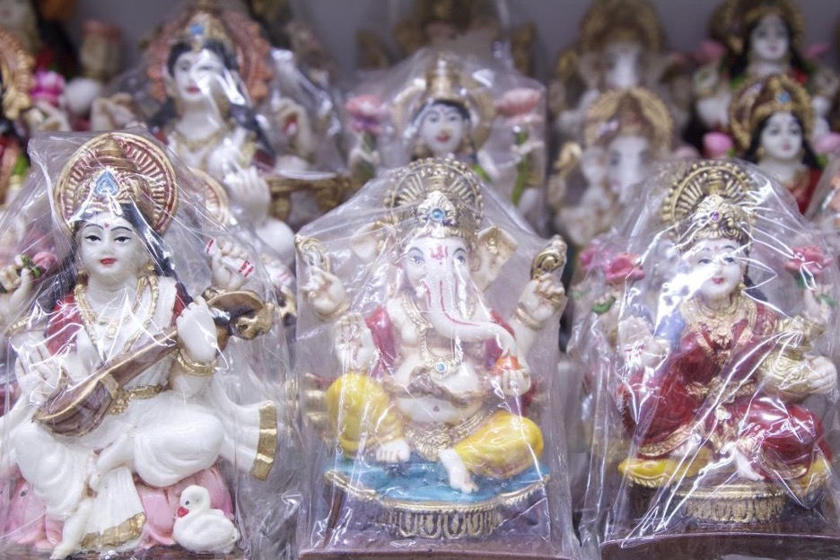 Rows of Hindu deity sculptures wrapped in plastic