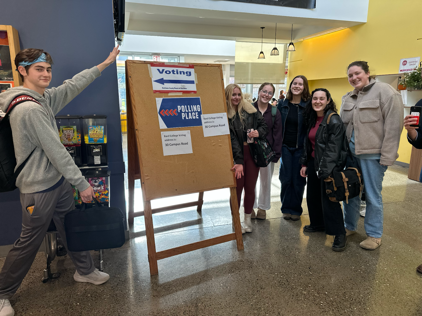 Students standing by a voting sign.