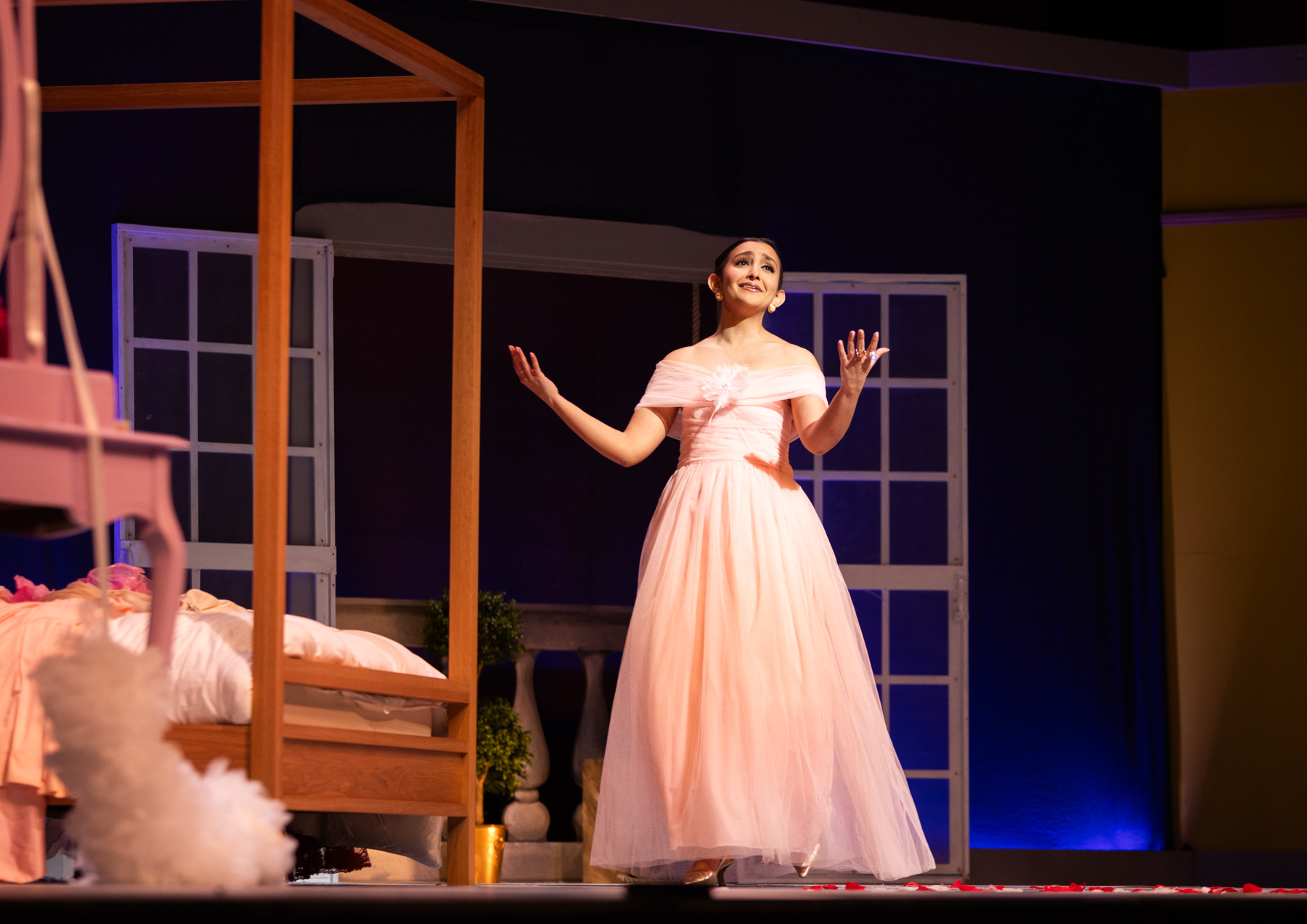 a woman in a pink dress sings on stage