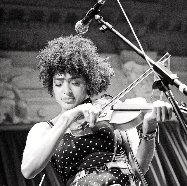 a black and white photo of a woman playing the violin