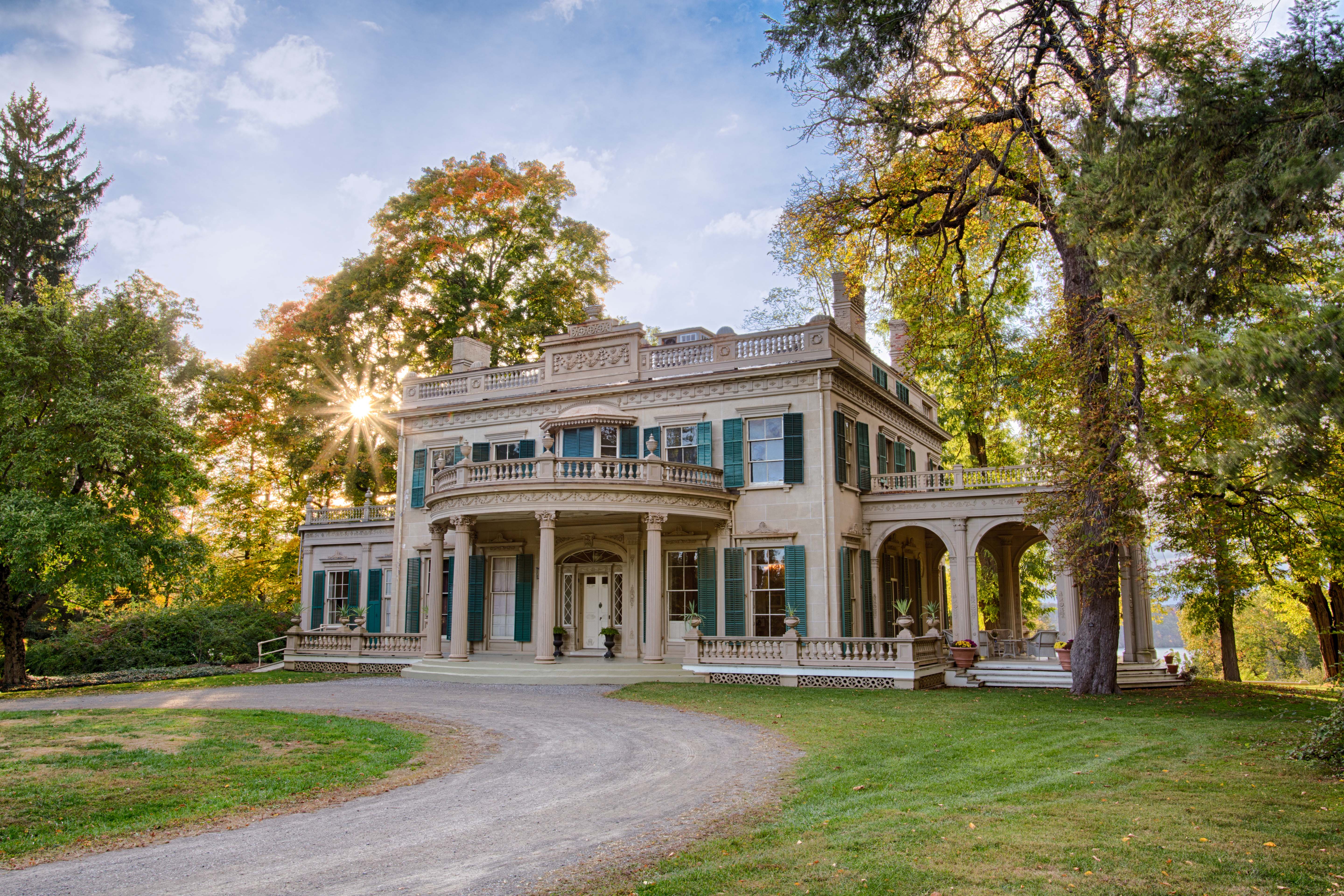 The Montgomery Place estate in the sunlight with trees surrounding it.