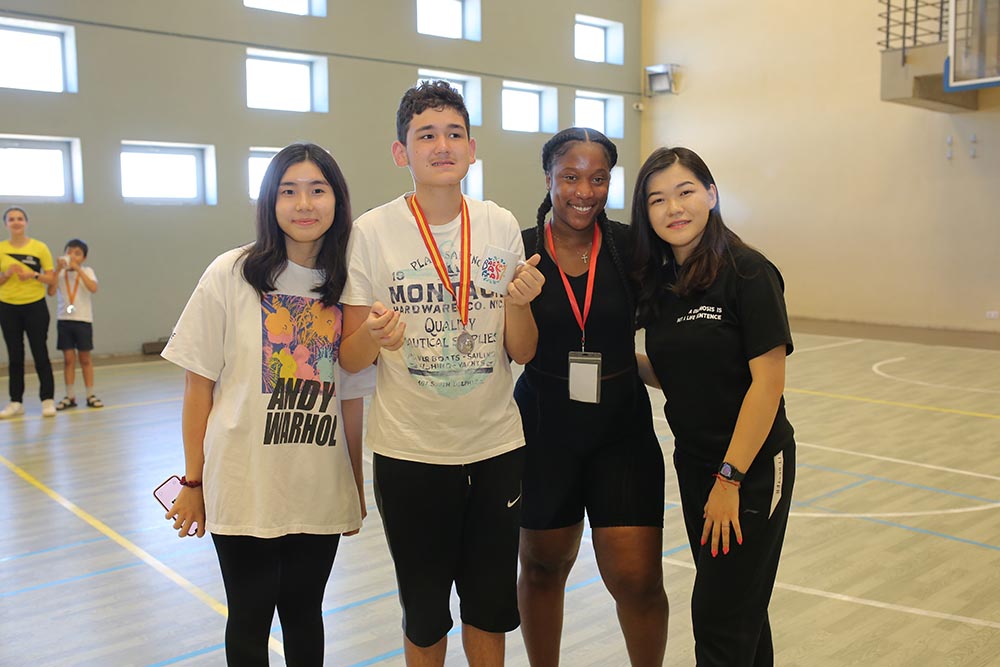 Saliya Khurova of AUCA (right), participates with two other students in a demonstration of Basketball for All, her project working with local children with Downs syndrome and autism. Photo courtesy of AUCA.